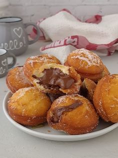 a white plate topped with chocolate covered donuts