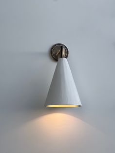 a white wall mounted light on the side of a gray wall