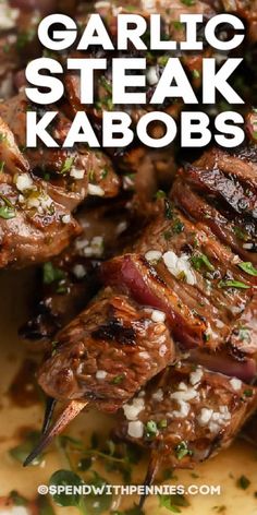 grilled steak kabobs with garnish on top and text overlay that reads garlic steak kabobs