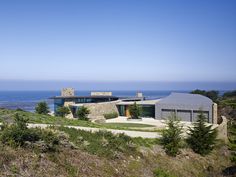 the house is on top of a hill overlooking the ocean