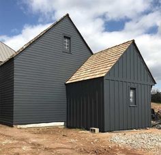 two gray buildings with brown shingles on the roof