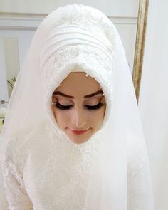 a woman wearing a white veil and holding a cell phone