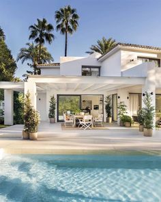 a large white house sitting next to a swimming pool