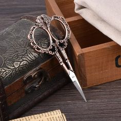 a pair of scissors sitting on top of a wooden box