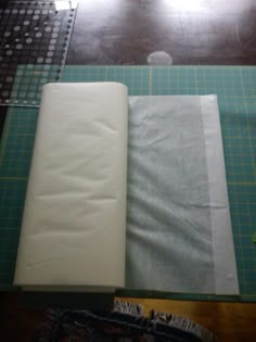 two pieces of fabric sitting on top of a cutting board