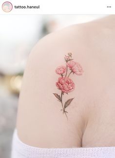 a woman's breast with pink flowers tattooed on her left shoulder and behind her back