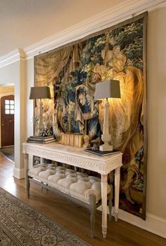 a room with a large tapestry on the wall and a bench in front of it