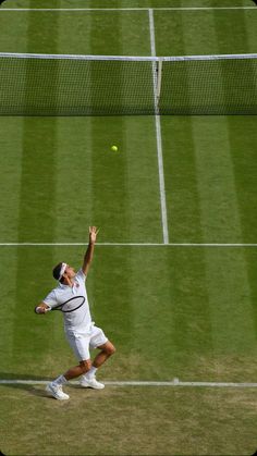 a tennis player reaching up to hit a ball with his racket on the court