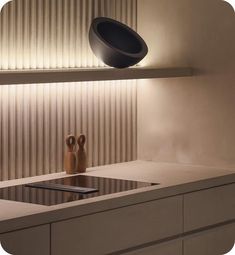 a modern kitchen with white counter tops and black lighting on the wall over the sink