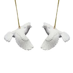 two white ceramic birds hanging from strings on a white background, one is shaped like a bird and the other is shaped like a dove