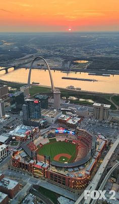 an aerial view of st louis baseball stadium and the gateway arch at sunset in st louis, missouri