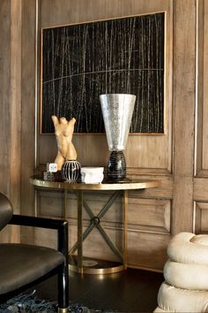 a table with two vases on it in front of a chalkboard and chair