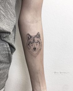 a wolf tattoo on the left arm