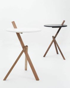 two wooden and white tables with one standing on the other, in front of a white background