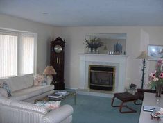 a living room filled with furniture and a fire place next to a wall mounted clock