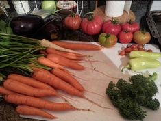 carrots, broccoli and other vegetables on a cutting board in a kitchen