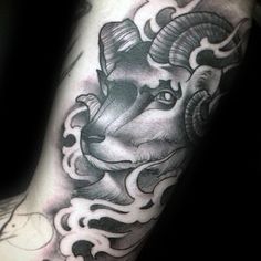 a black and white photo of a ram tattoo on the arm