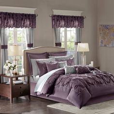 a bed room with a neatly made bed and purple comforter