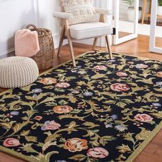 a black rug with flowers on it in front of a white chair and window sill