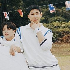 two young men standing next to each other in front of some flags and bunting