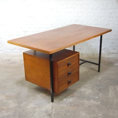 a wooden table with two drawers on it and a brick wall in the back ground