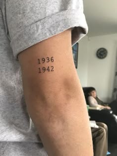 a person with a tattoo on their arm that reads, 1932 - 42 and has numbers tattooed on it