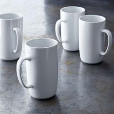 four white coffee mugs sitting on top of a table