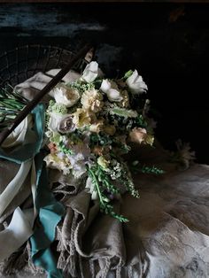 a bouquet of flowers is sitting on a table with cloths and napkins around it