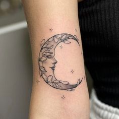 a woman's arm with a crescent moon tattoo on it