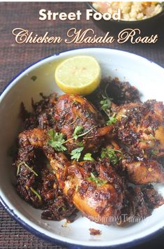 chicken masala roast in a bowl with lemon wedges