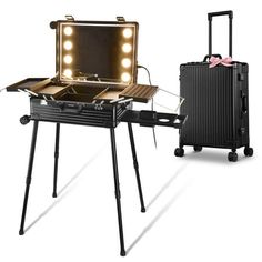 an open suitcase sitting on top of a tripod next to a vanity with lights