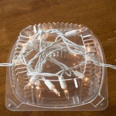 there are some white lights in the plastic container on the table and it looks like they have been tangled together