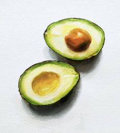 two halves of an avocado on a white surface