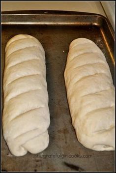 two loaves of bread sitting on top of a pan