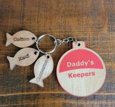 wooden keychain with two fish and the words daddy's keepers on it