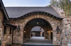 an arched entrance to a stone building with lights hanging from it's side walls