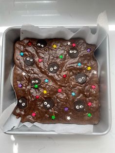 a cake in a pan with buttons and stars on it's side, ready to be eaten