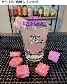 pink starburst is sitting on top of a table next to some candy cubes