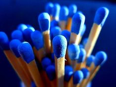 several blue and yellow matchesticks in a cup