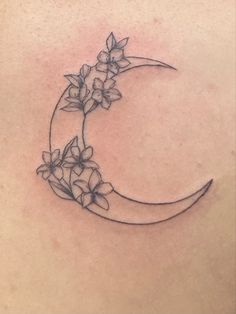 the back of a woman's stomach with flowers on it and a half moon