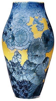 a blue and yellow vase sitting on top of a table