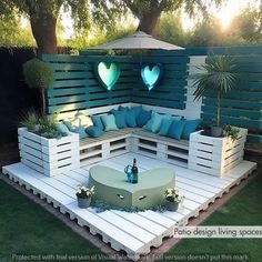 an outdoor seating area made out of pallets with blue pillows and heart shaped cushions