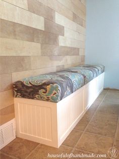 a bench sitting in the middle of a room with tile on the floor and walls