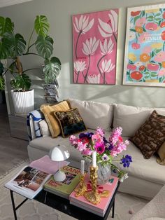 a living room filled with lots of furniture and flowers on top of a coffee table