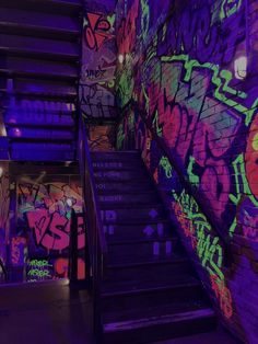 the stairs are covered in graffiti and lit by colorful lights