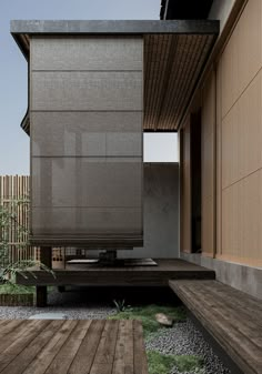 an outdoor area with wooden decking and large sliding doors on the side of it