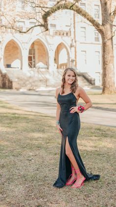 a woman in a long black dress posing for a photo with her hand on her hip