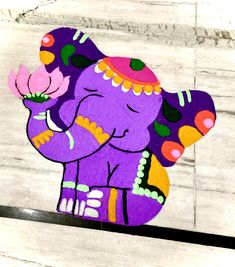 an elephant painted on the side of a wooden wall with a flower in it's trunk