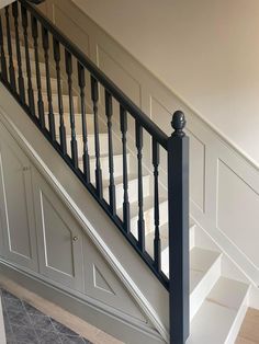 a staircase with black railing and white handrails