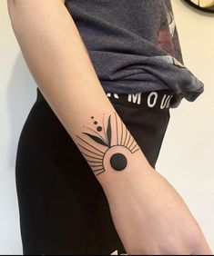 a woman's arm with a tattoo on it and a clock in the background